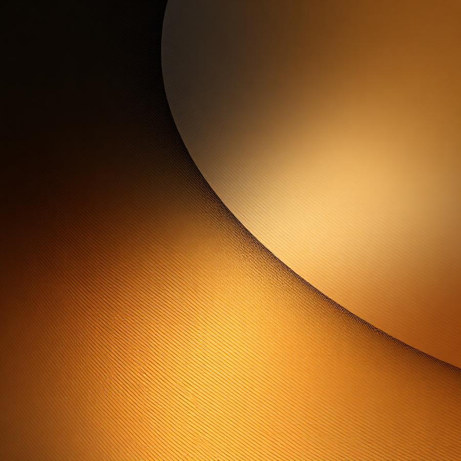 Soft gradient of amber light curving against darkness
